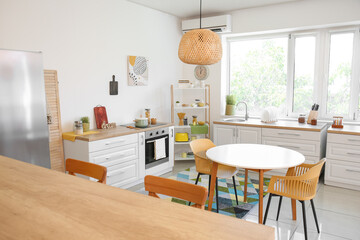 Dining table with chairs in modern interior of kitchen