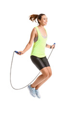Sporty young woman jumping rope on white background