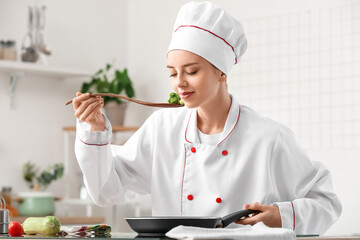 Female chef tasting fried broccoli in kitchen