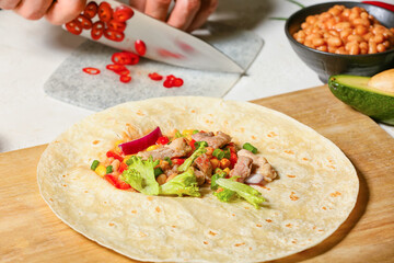 Tortillas with fresh ingredients for preparing tasty burrito on white background