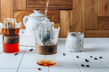 Ground drip coffee using paper type filter with coffee beans on white ceramic tiles background