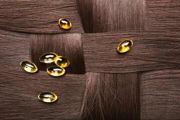 Fish oil pills on brunette hair, closeup