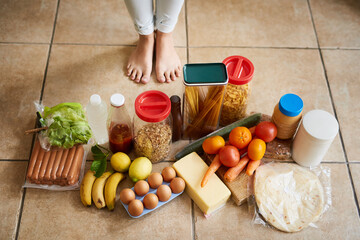 Keeping her kitchen fully stocked. High angle shot of a woman surrounded by various food in the kitchen at home.