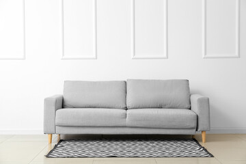 Modern sofa near white wall
