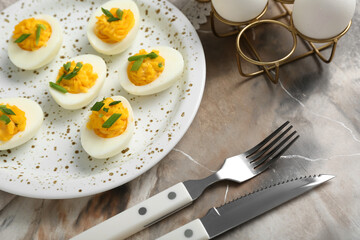 Cutlery, plate and holder with eggs on grunge background. Easter celebration