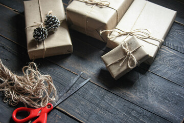 gift wrapping from Kraft paper wrapped with twine, the concept of handmade, placed on black wooden table