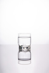 A splash of water in a glass on a light background. fresh water glass with bubbles white background