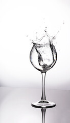 A splash of water in a glass on a light background. fresh water glass with bubbles white background