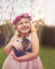 He wants to come home with us. Shot of a happy little girl holding a kitten and looking into the distance while standing outside in nature.