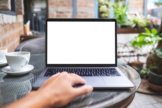 Mockup image of a woman using laptop computer with blank white desktop screen in the outdoors
