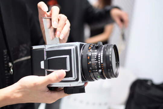 The photographer holding the camera in hand at the studio.