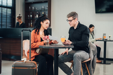 Diverse business partners sitting in modern airport lounge with
