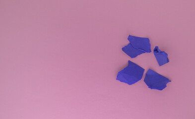 A bunch of balls of crumpled purple paper on a pink background. The concept of minimalism, a copy of the space on the left