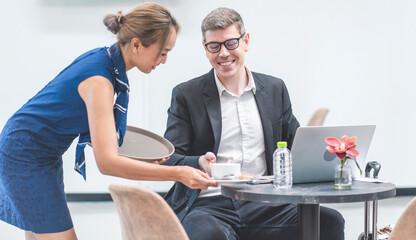 Obraz premium Waitresses provide water and beverages to business travelers on transit at the airport lounge.