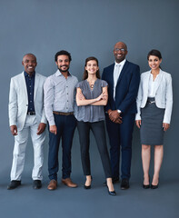 Obraz premium We here for the opportunity. Studio shot of corporate businesspeople posing against a gray background.