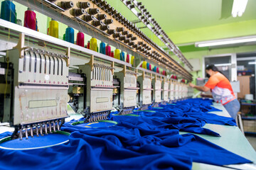 A worker working with sewing machine, Embroidery area in textile factory in industrial zone with...