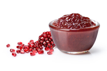 Pomegranate marmalade jam in glass bowl with fresh fruit isolated on white background.