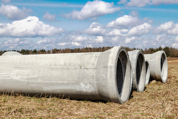 Reinforced concrete storm sewer pipes of large diameter stacked at a construction site. Sewer Large...