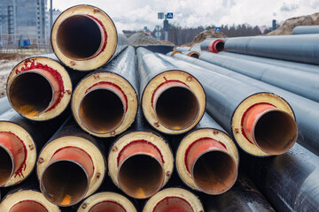 Insulated pipe. Large metal pipes with a plastic sheath at a construction site. Modern pipeline for supplying hot water and heating to a residential area.