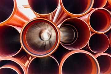Orange sewer pipes at the construction site. Preparation for the installation of an underground sewer system. Wastewater disposal.
