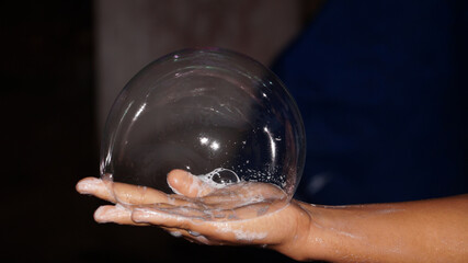 Big soap foam bubble on the palm