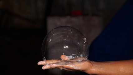 Big soap foam bubble on the palm