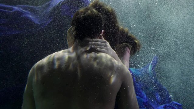 embrace and hug of lovers underwater, young woman in love is hugging naked torso of brawny boyfriend