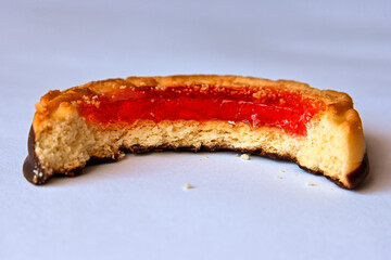 bitten biscuits with red jam close up, macro