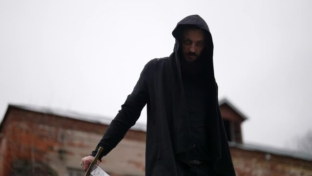 aggressive mysterious man with sword is looking at camera, medieval warrior or warlock