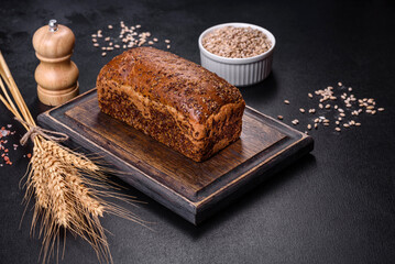 Fresh baked brown bread with ears and grains of wheat