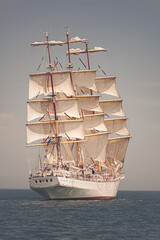 Naklejka na ściany i meble Old ship with white sales sailing in the sea