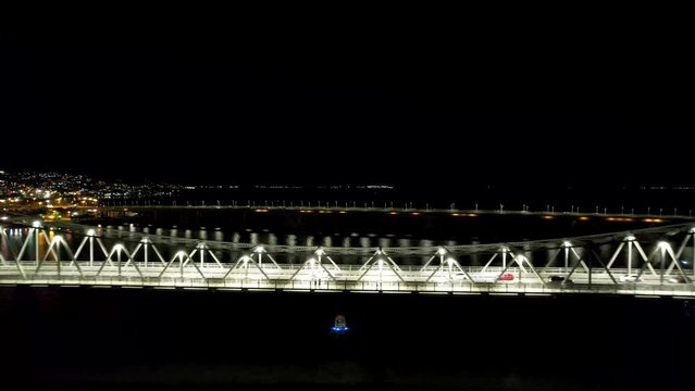 Aerial Break Away Revealing Long Famous Hercílio Luz Florianopolis City Bridge Reflecting Lights in Water Below Santa Catarina Brazil Night Drone 4k