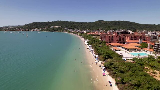 Aerial Downward Tilt Along Vibrant Green Blue Tropical Shoreline of Jurere International Beach Florianopolis Santa Catarina Brazil Summer Drone 4k