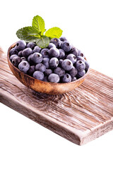 Bowl of fresh blueberries on rustic wooden board. Organic food blueberries and mint leaf for healthy lifestyle.