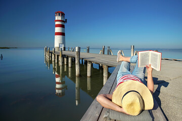 woman enjoy her day near the lighthouse, reading a book