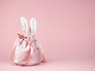 Pink baggie with bunny ears on a pink background. The concept of Easter, a gift