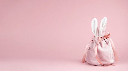 Pink baggie with bunny ears on a pink background. The concept of Easter, a gift