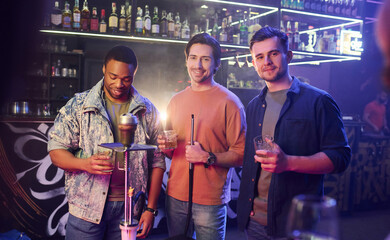 Blue lighting interior. Group of friends having fun in the night club together