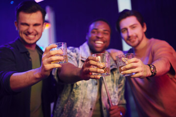 Knocking glasses. Group of friends having fun in the night club together