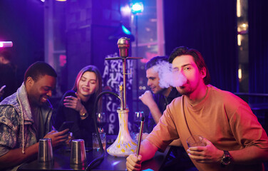 Looking into the camera. Group of friends having fun in the night club together