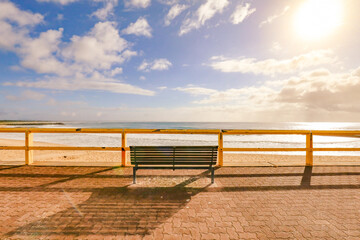 Fototapeta premium Empty park bench seat with beautiful beach view early in the morning at Forster Beach, NSW Australia