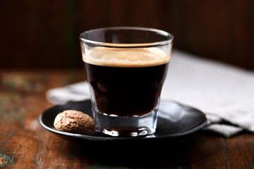 Coffee in glass cup on dark wooden background. Close up.	
