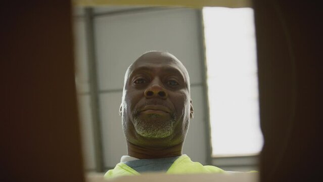 Point of view shot of male worker in distribution warehouse closing and sealing box - shot in slow motion