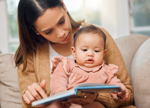 She loves a good picture book. Shot of a woman reading to her baby girl.