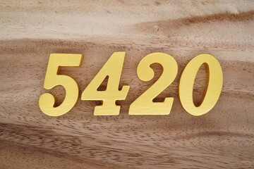 Golden Arabic numerals on a real brown and white wooden floor number 5420