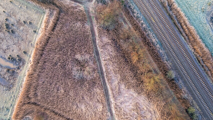Misty Sunrise over hoarfrosted Wetlands and meadows, RSPB Exminster and Powderham Marshe from a drone, Exeter, Devon, England