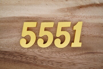 Golden Arabic numerals on a real brown and white wooden floor number 5551