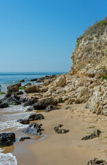 Seascape, sea, ocean, water, beach, sand, stones, cliff, rock, escarpment.