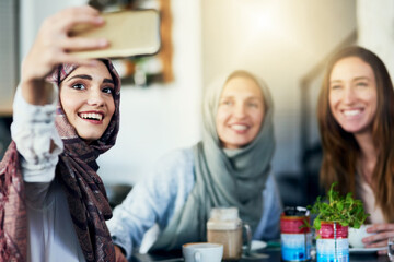 I cant espresso how much they mean to me. Shot of a group of women taking selfies with a mobile phone in a cafe.