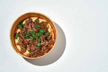 Hummus with beef kebab in a delivery box on an white background - obrazy, fototapety, plakaty
